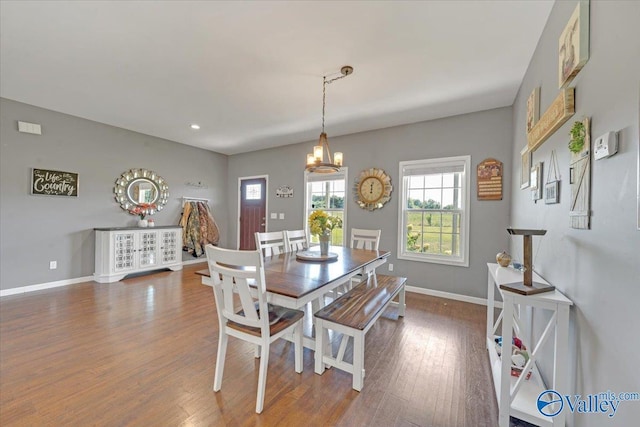 dining room with a chandelier, baseboards, and wood finished floors