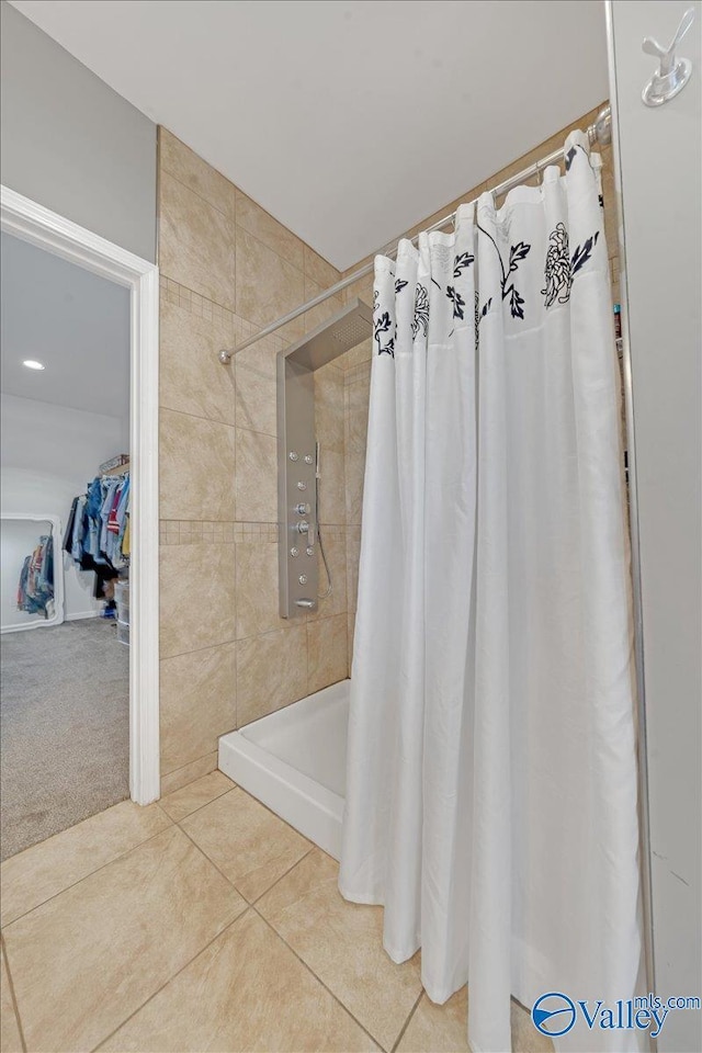 full bathroom featuring a tile shower and tile patterned floors