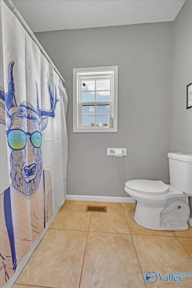 bathroom with toilet, tile patterned flooring, visible vents, and baseboards
