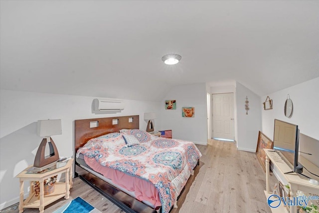 bedroom featuring vaulted ceiling, a wall mounted AC, baseboards, and wood finished floors