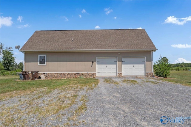 view of side of home featuring roof with shingles, driveway, and an attached garage