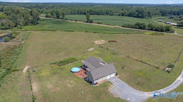 drone / aerial view with a wooded view and a rural view