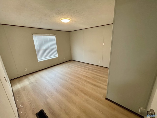 unfurnished bedroom featuring a textured ceiling and light wood finished floors