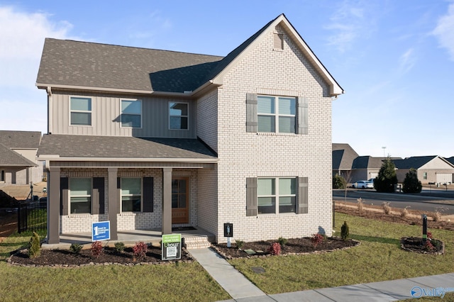 view of front of house featuring covered porch and a front lawn