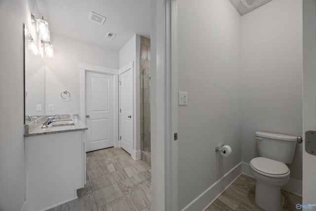 bathroom with vanity, walk in shower, and toilet