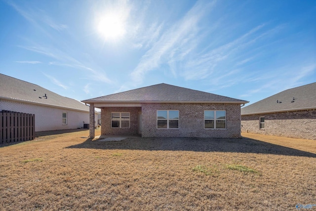 back of house with central AC and a lawn