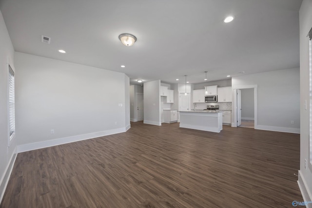 unfurnished living room with sink and dark wood-type flooring