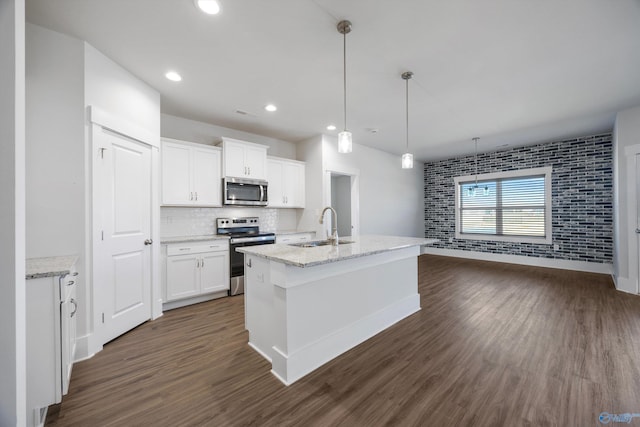 kitchen with sink, white cabinetry, light stone counters, hanging light fixtures, and appliances with stainless steel finishes