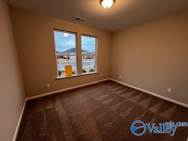 carpeted spare room featuring a water view