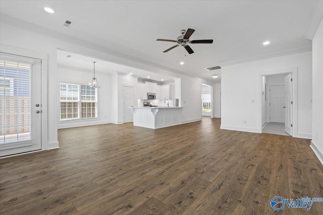 unfurnished dining area featuring plenty of natural light, dark hardwood / wood-style floors, ornamental molding, and a chandelier