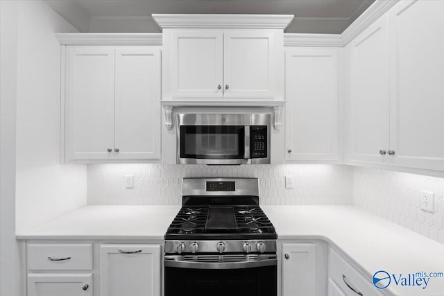 kitchen with backsplash, white cabinets, ornamental molding, and appliances with stainless steel finishes