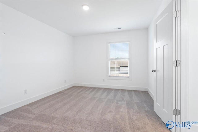 spare room featuring light colored carpet