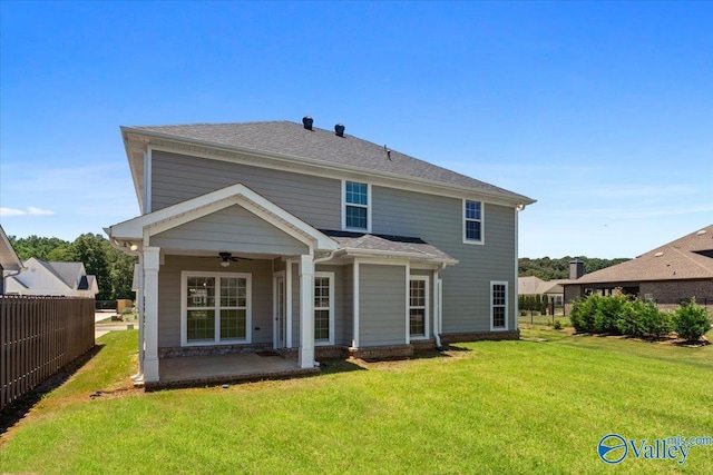 back of property featuring ceiling fan and a lawn