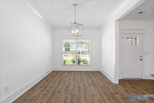 unfurnished dining area with a chandelier, dark hardwood / wood-style floors, and ornamental molding