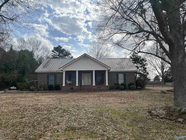 ranch-style house featuring covered porch and a front lawn