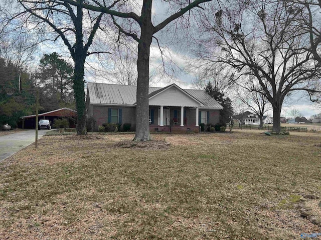 single story home featuring a front yard, a carport, and a porch