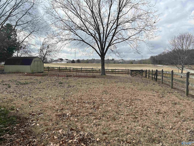 view of yard with a shed and a rural view