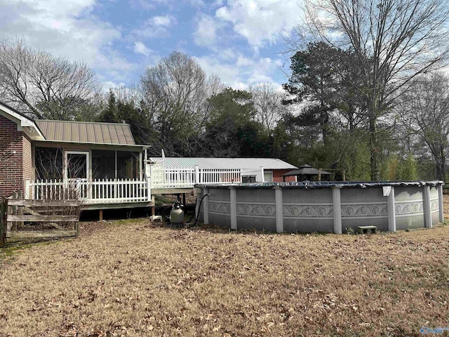 rear view of property with a yard and a sunroom