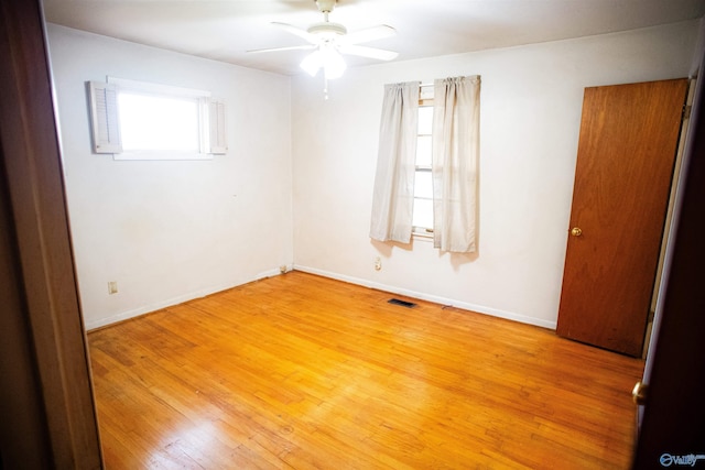 unfurnished room featuring light wood-style floors, a healthy amount of sunlight, and visible vents