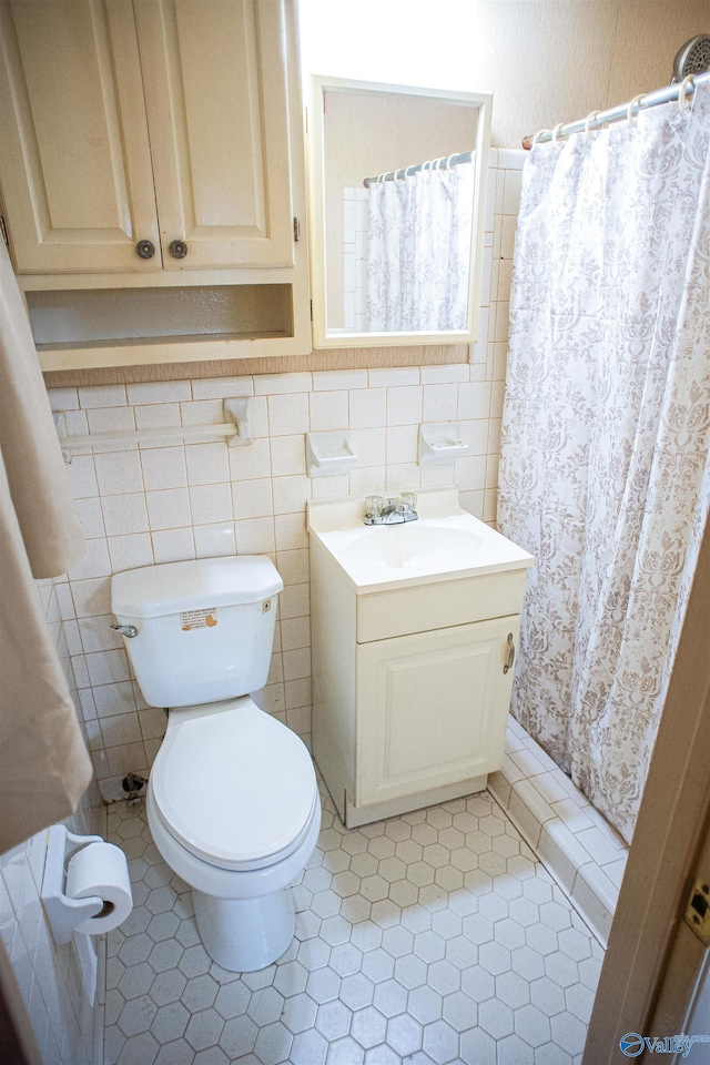 bathroom featuring a shower with shower curtain, toilet, tile walls, and vanity