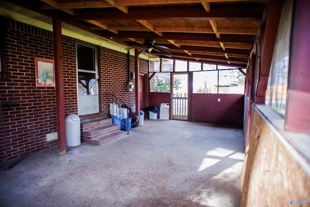 unfurnished sunroom with ceiling fan