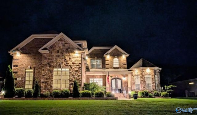 french country home with a lawn, french doors, and stone siding