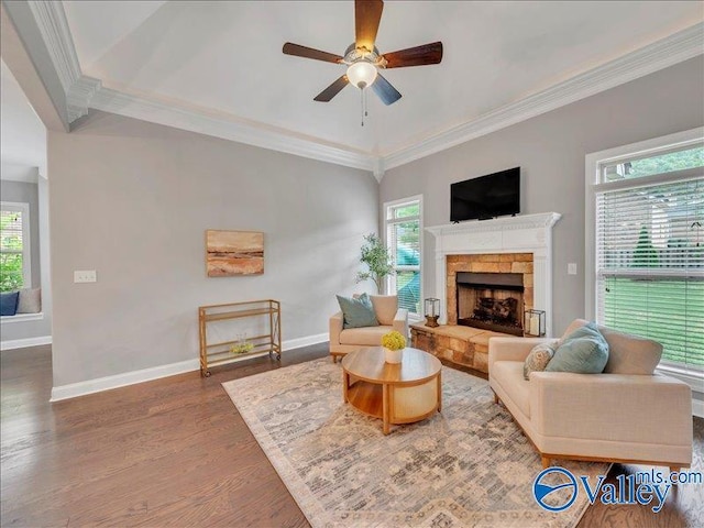 living area featuring crown molding, baseboards, a ceiling fan, and wood finished floors