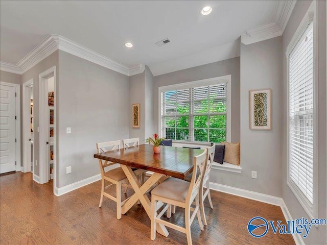 dining room with crown molding, baseboards, and wood finished floors