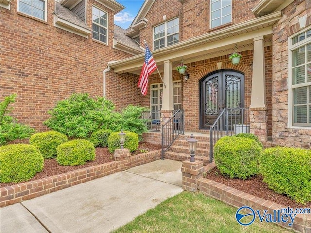 property entrance with a porch and brick siding