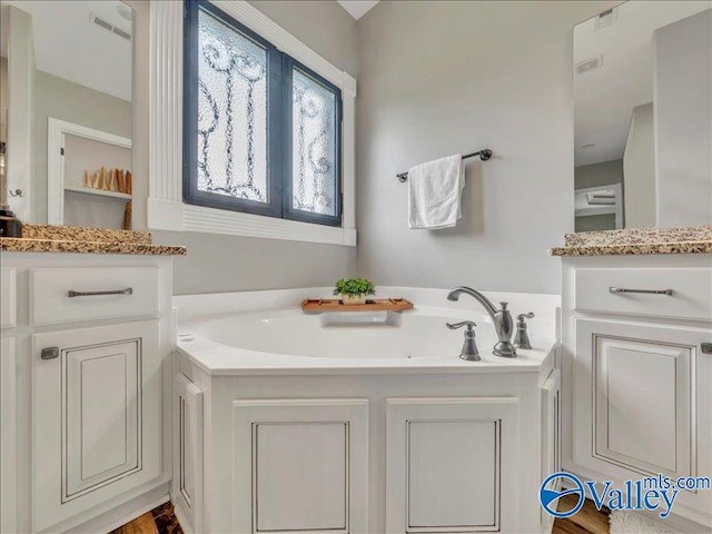 bathroom featuring a garden tub and visible vents