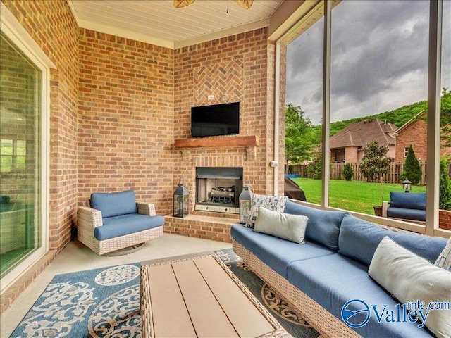 sunroom / solarium featuring a ceiling fan and an outdoor living space with a fireplace