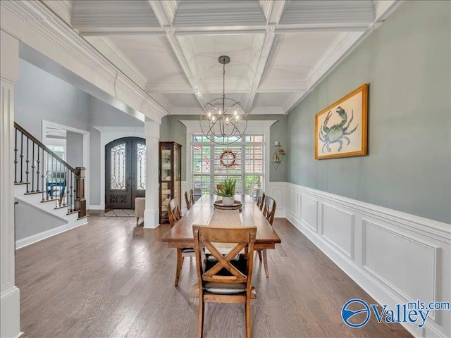 dining space with a notable chandelier, french doors, stairs, wood finished floors, and beamed ceiling