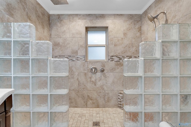 bathroom featuring vanity, tiled shower, and ornamental molding