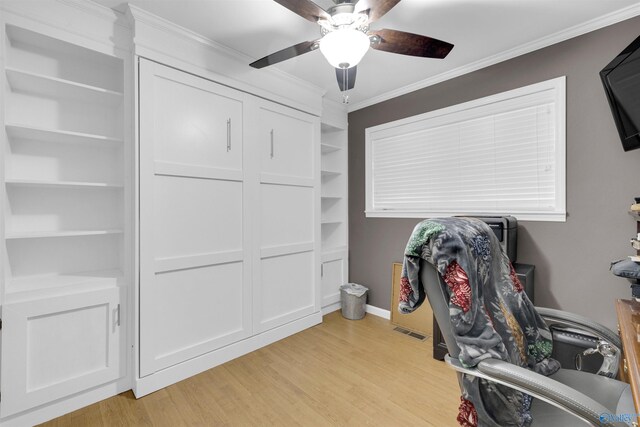 office featuring ceiling fan, built in shelves, ornamental molding, and light wood-type flooring