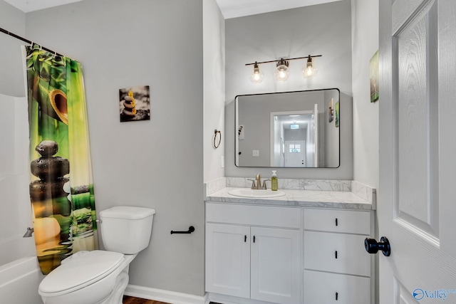 bathroom with toilet, vanity, and baseboards