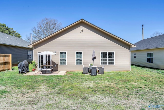 rear view of house featuring a lawn and a patio area