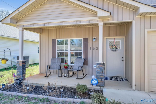 entrance to property with central air condition unit, board and batten siding, and a porch