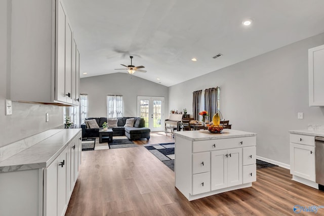 kitchen featuring vaulted ceiling, visible vents, wood finished floors, and a ceiling fan