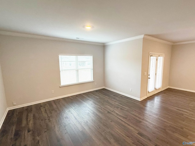 empty room with dark wood-style floors, baseboards, and ornamental molding