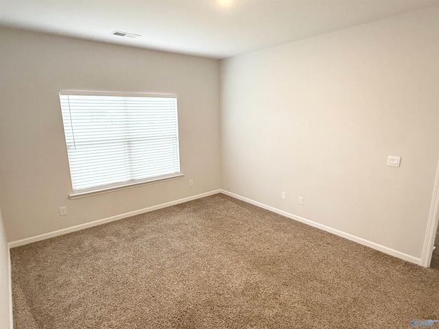 unfurnished room featuring dark carpet and baseboards