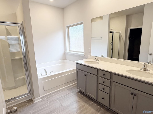 full bathroom featuring a sink, a stall shower, double vanity, and a bath