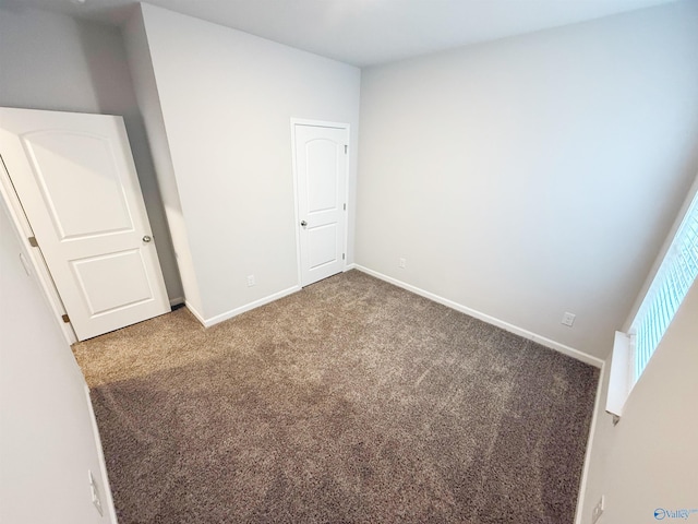 unfurnished bedroom with baseboards and carpet flooring