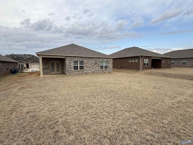 back of property with french doors and brick siding