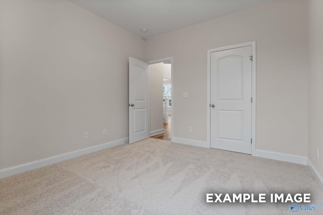 unfurnished bedroom featuring light carpet