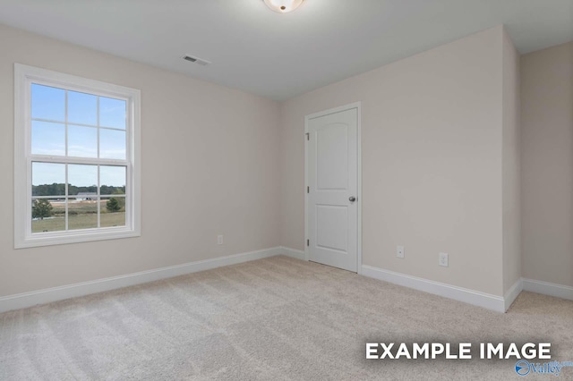 unfurnished room featuring light colored carpet