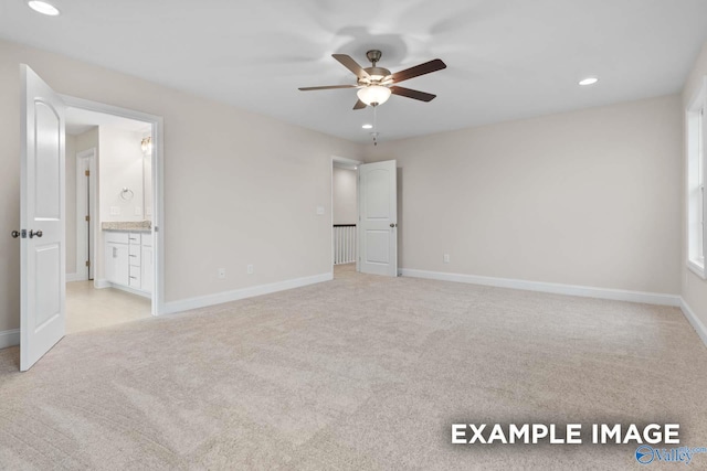 unfurnished bedroom featuring ceiling fan, ensuite bathroom, and light colored carpet