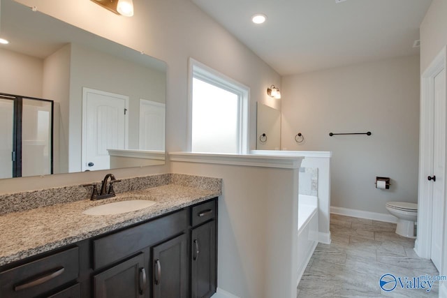 108 Ivy Vine Dr, Toney, AL 35773 - bathroom featuring vanity, toilet, baseboards, marble look tile flooring, and a garden tub