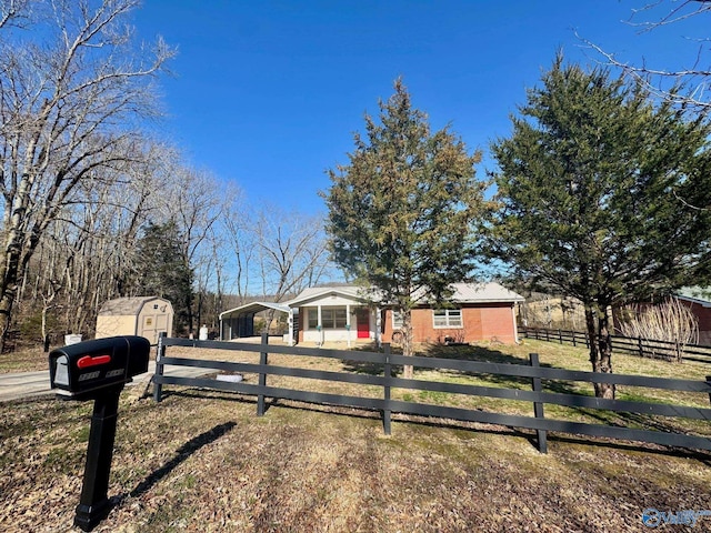 single story home with a fenced front yard, an outbuilding, and a storage unit