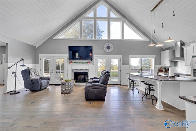 living room featuring wooden ceiling, dark wood-type flooring, high vaulted ceiling, french doors, and sink