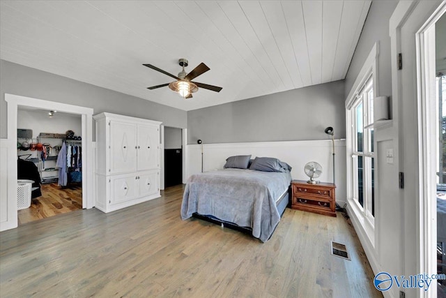 bedroom featuring a closet, ceiling fan, light hardwood / wood-style flooring, and a spacious closet